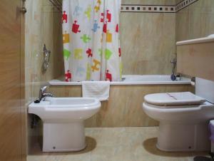 a bathroom with a toilet and a sink and a tub at Apartamentos Turísticos Fercomar in Nerja