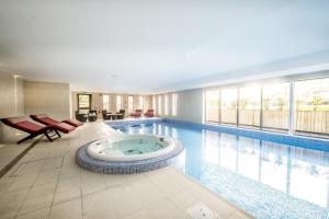 uma piscina com uma banheira de hidromassagem no meio em Fonab Castle Hotel em Pitlochry