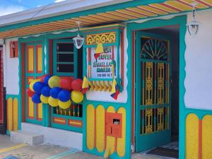 un frente de tienda colorido con globos delante en Casa Familiar María E, en Filandia