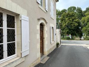 a building with a door on the side of a street at Appartement avec jardin Villeveque 