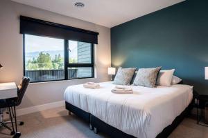 a bedroom with a large bed with a window at Northern Exposure by Revelstoke Vacations in Revelstoke