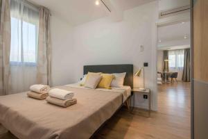 una camera da letto con un grande letto con asciugamani di Villa 64 Apartment #1 a Mlini