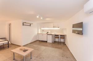 ein Wohnzimmer mit einem Tisch und einer Küche in der Unterkunft Apartments Villa Vista Sol in Vodice