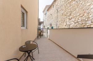 a small table and chairs sitting on a sidewalk next to a building at Apartments Villa Vista Sol in Vodice