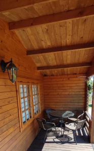 a patio with a table and chairs in a cabin at Pas Jūratę namelių nuoma Šventojoje in Šventoji