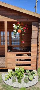 a wooden building with a table and flowers in it at Pas Jūratę namelių nuoma Šventojoje in Šventoji