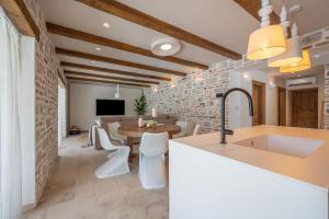 a kitchen and dining room with a stone wall at Villa Cera in Unešić