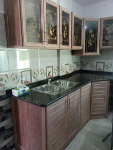 a kitchen with a sink and wooden cabinets at فيلا بوابة جرش الرومانيه الشماليه in Jerash