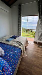 a bedroom with a bed and a large window at Village as casinhas in Uruçuca +84 photos