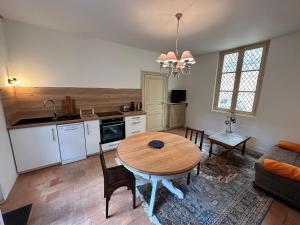 a kitchen and living room with a table and a couch at Appartement avec jardin Villeveque 