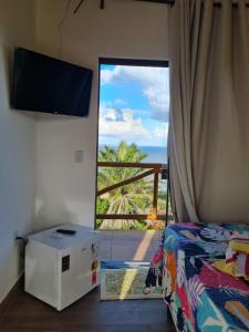 a bedroom with a bed and a view of the ocean at Village as casinhas in Uruçuca