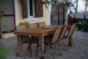 una mesa de madera y sillas en un patio en metaxas house, en Mikros Gialos