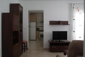 a living room with a television and a kitchen at Apartamentos Turísticos Fercomar in Nerja