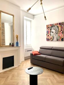 a living room with a couch and a mirror at Grands T2 Cours Napoleon in Ajaccio