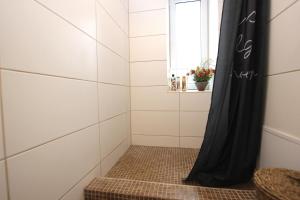 y baño con ducha y cortina negra. en Riga Mezaparks apartment + private parking en Riga