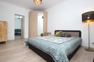 Un dormitorio con una cama y una lámpara. en Riga Mezaparks apartment + private parking en Riga