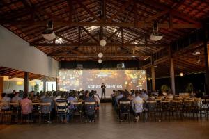 a large group of people sitting at tables in a room at Cabanas Portal da Serra in Mogi das Cruzes