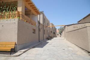 une allée vide avec un banc sur le côté d'un bâtiment dans l'établissement Rasul-Nazar, à Khiva