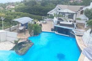 uitzicht over een groot blauw zwembad bij Chez Charlotte et Axel in Punaauia