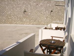 een kamer met een tafel en stoelen en een muur bij Katerina Apartments in Triovasálos