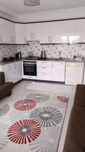 una cocina con armarios blancos y una alfombra en el suelo en 2 Yatak Odalı Daire-Fethiye, en Fethiye