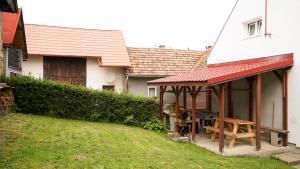 ein Haus mit einer Veranda mit einem Tisch und einem Grill in der Unterkunft Holiday House Mária in Závažná Poruba