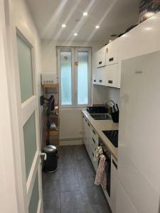 eine Küche mit einem weißen Kühlschrank und einer Spüle in der Unterkunft Saint ouen: superbe appartement in Saint-Ouen