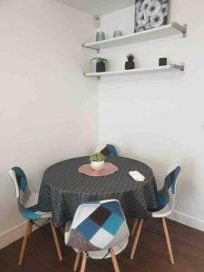 einen Esstisch und Stühle mit einem Tisch und einer Pflanze in der Unterkunft Saint ouen: superbe appartement in Saint-Ouen