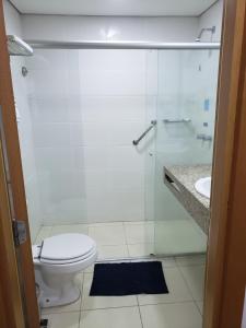 a bathroom with a toilet and a glass shower at Apto Hotel Blue Tree Manaus in Manaus