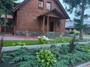 a brick house with a garden in front of it at Mieszkanie - Apartament in Dąbrowa