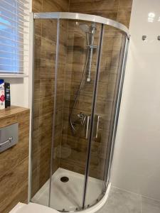 eine Dusche mit Glastür im Bad in der Unterkunft Mieszkanie - Apartament in Dąbrowa