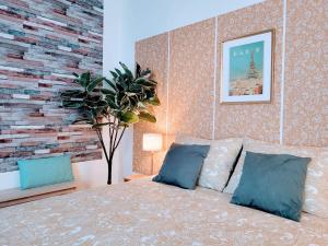 een slaapkamer met een bed en een bakstenen muur bij Cosy Case proche Paris Montmartre in Saint-Ouen