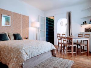 聖旺的住宿－Cosy Case proche Paris Montmartre，卧室配有一张床和一张桌子及椅子