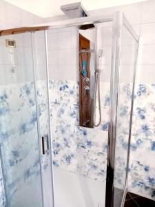 y baño con ducha y papel pintado azul y blanco. en Once Upon a Time, en Centenaro