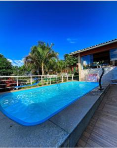 a swimming pool with a blue surfboard on top of it at Pousada Santa Helena in Iriri