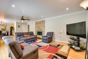 a living room with two couches and a flat screen tv at Rockville Home Patio Oasis, Fireplace, Near DC! in Rockville