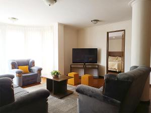 sala de estar con sofás y TV de pantalla plana. en Hotel San Felipe, en Sucre