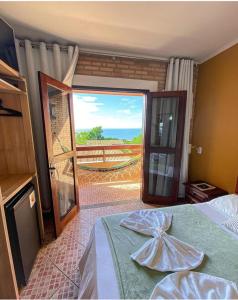 a bedroom with a bed and a view of the ocean at Pousada Santa Helena in Iriri