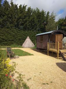 a house and a tent and a bench and a teepee at Shirehill Farm in Chippenham