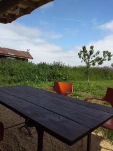a wooden picnic table with chairs in a field at Shirehill Farm in Chippenham