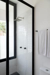 uma casa de banho com um chuveiro e uma porta de vidro em Pucté Bacalar em Bacalar