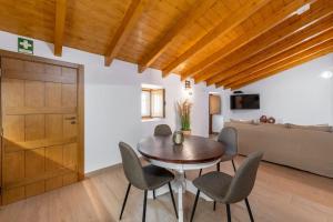 a dining room with a wooden door and a table and chairs at Casa do Poço (Vale Luis Neto-Retiro do Caldeirão) in Loulé
