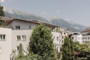 a group of buildings with mountains in the background at Das Grüne Haus - Boutique Apartments ecofriendly in Innsbruck