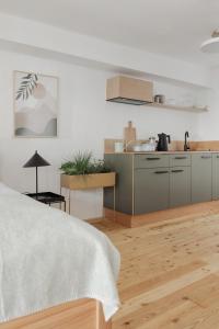 a kitchen with white walls and a wooden floor at Das Grüne Haus - Boutique Apartments ecofriendly in Innsbruck