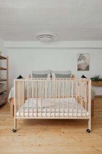 ein weißes Kinderbett in einem Zimmer mit einem Bett in der Unterkunft Das Grüne Haus - Boutique Apartments ecofriendly in Innsbruck