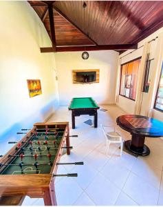 a room with a pool table and a table at Pousada Santa Helena in Iriri