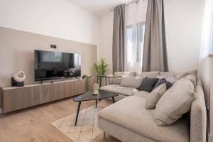 uma sala de estar com um sofá e uma televisão de ecrã plano em Villa 64 Apartment #2 em Mlini