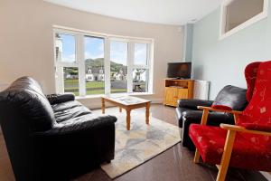 a living room with two couches and a tv at Downings Coastguard Cottages - Type B-E in Downings