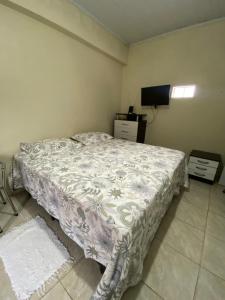 1 dormitorio con 1 cama y TV en Pousada da Tetê, en Porto Alegre