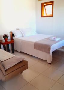 um quarto com uma grande cama branca e uma janela em Por do Sol em Florianópolis